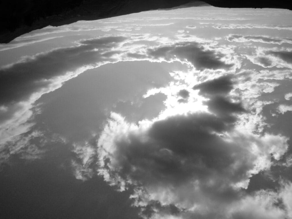 View of a sky over plateaus, with a crown formation of clouds, whose relief is enhanced by the sun hidden behind.
