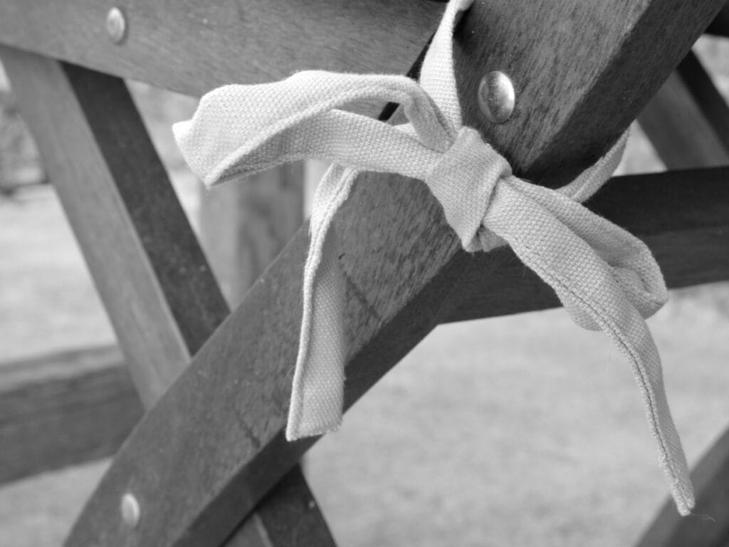 A close-up view of a garden chair post, where the cushion knot is tied.