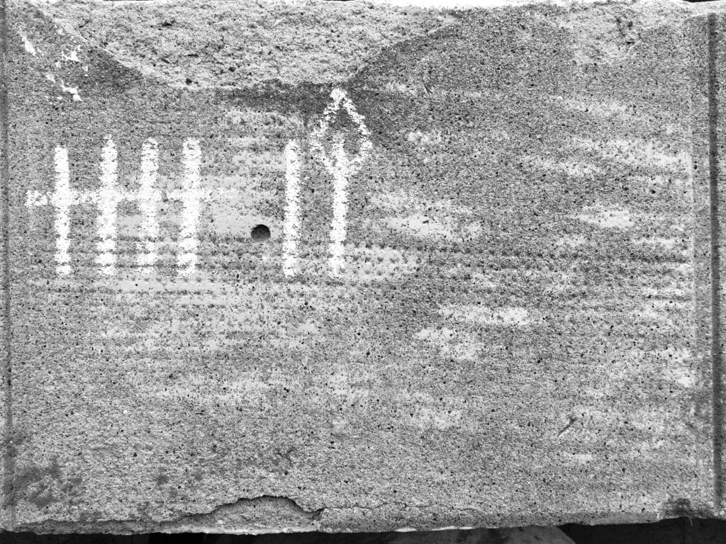 Seven bars drawn in chalk on a wall, the last of which is shaped like a birthday candle. They represent the first seven days of lockdown.