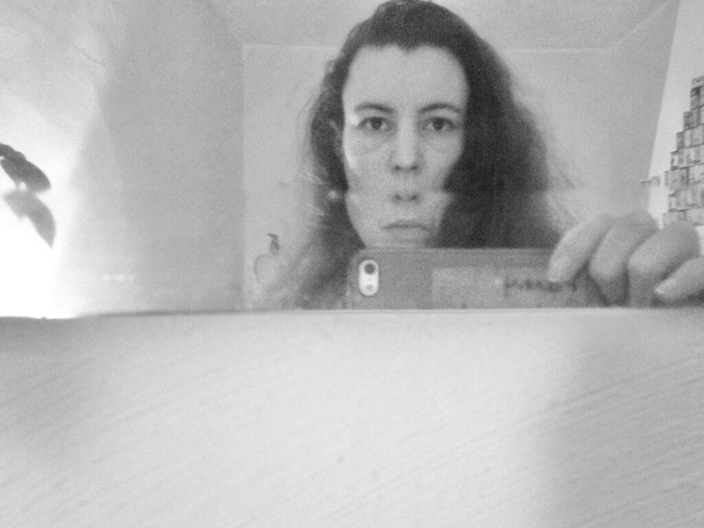 Self-portrait of the photographer in a bevelled mirror that makes er look like e has two noses, haha.
