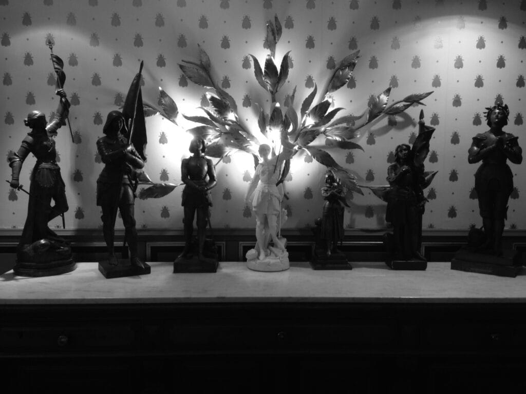 Dresser top covered with statuettes of Joan of Arc.