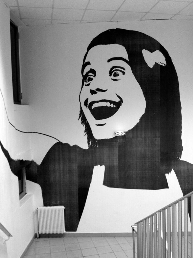 Large fresco on the wall at the end of the corridor depicting a person with a hallucinated expression.