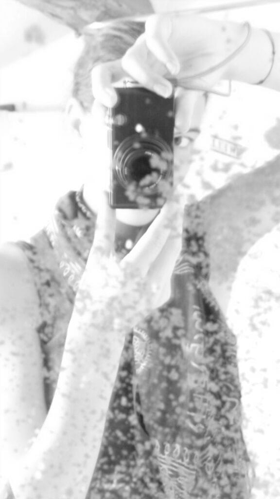 Self-portrait of the photographer in a spotted mirror.