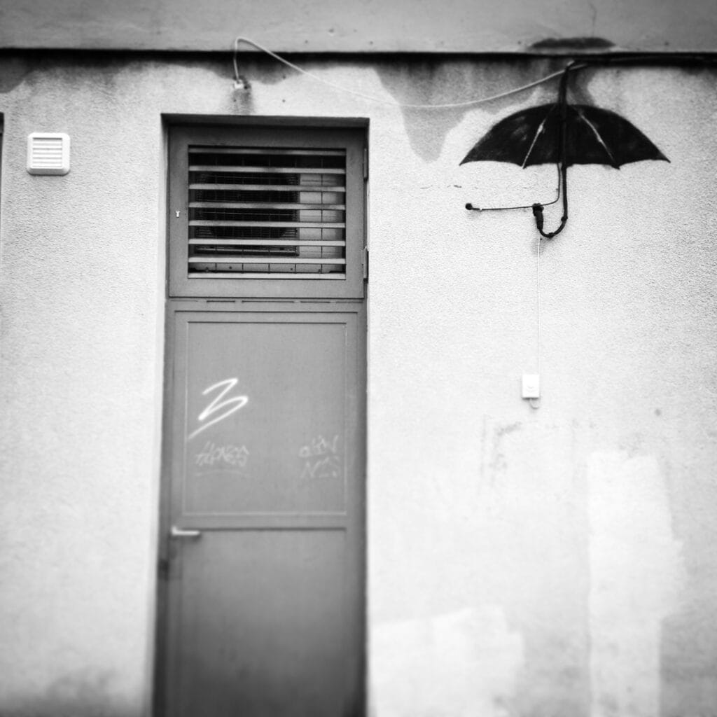 Umbrella graffiti that uses an electric cable to represent the handle.