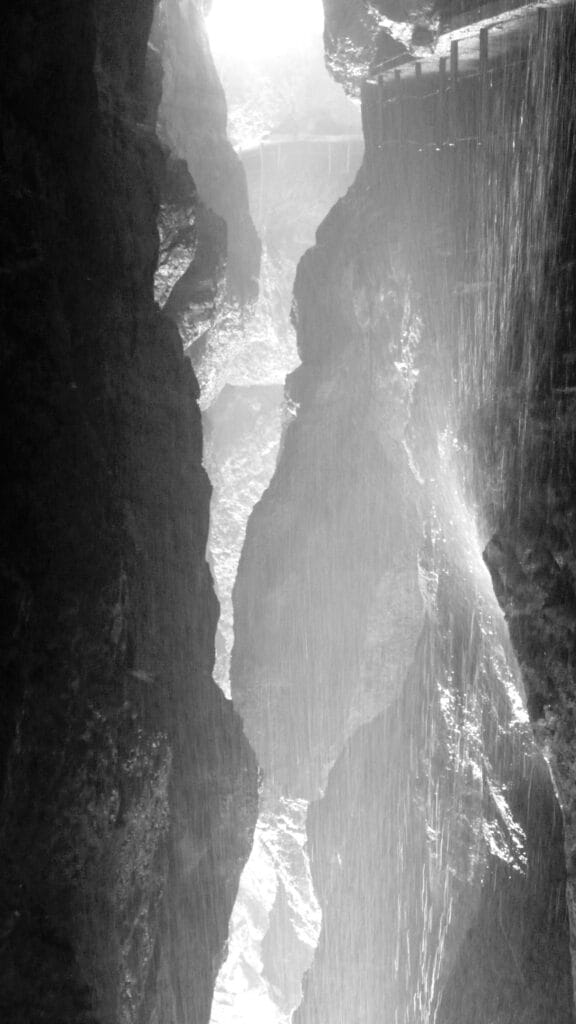 Collateral shower of a waterfall in a narrow, winding gorge.