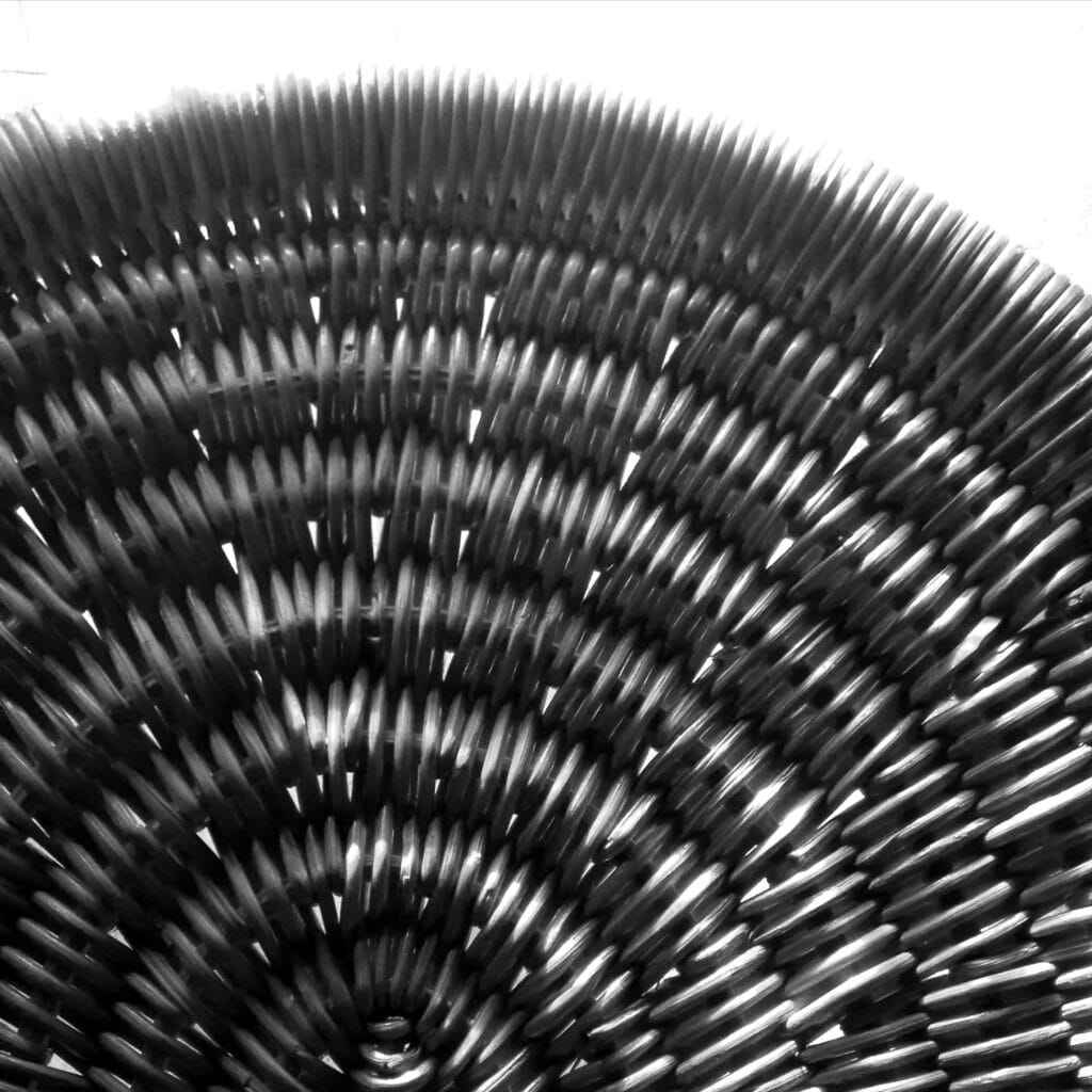 Close-up of the head of a wicker rocking chair with an overexposed background.