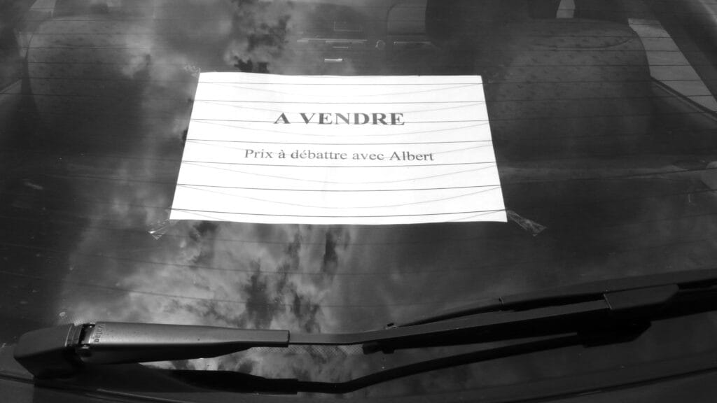 An advertisement taped to the rear window of a car reads: 'For sale. Price to be discussed with Albert'.