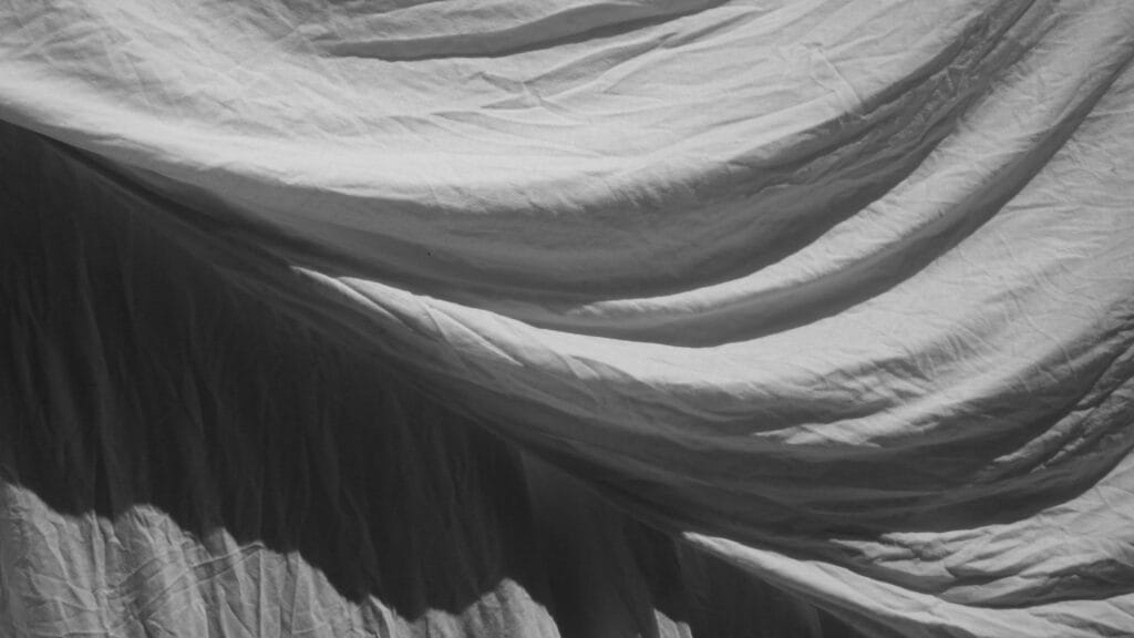 Draped sheets drying on the washing line.