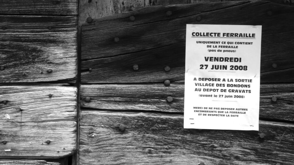 Poster on a barn door that reads: 'Scrap metal collection. Only scrap metal (no tyres). Friday 27 June 2008. Drop off at the rubble dump at the exit of Les Bondons village (before 27 June 2008). Please do not deposit any bulky items other than scrap metal, and keep to the date.'