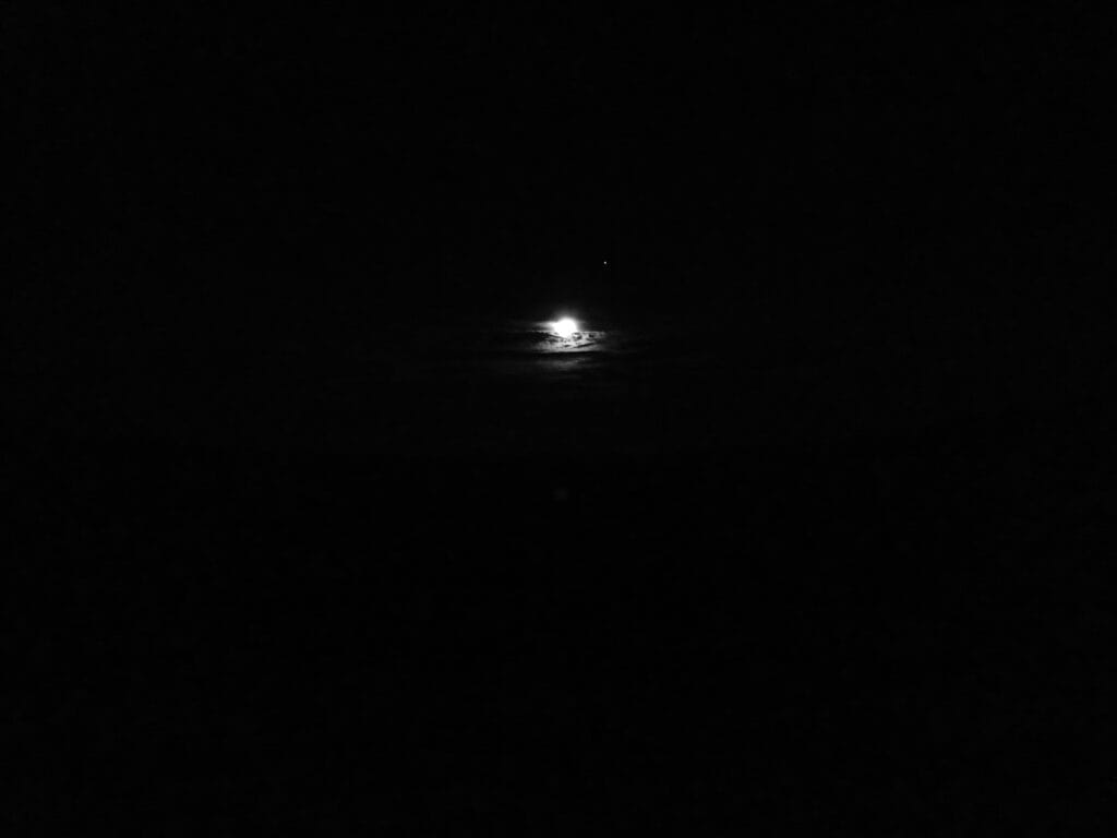 It is all black, except for the full moon behind a small bank of clouds in the centre, and the Venus next to it.