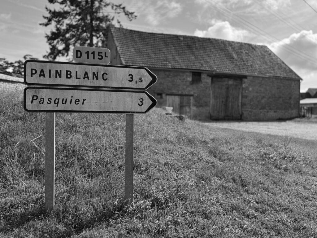 Two signs along the road indicating the village of ‘Pain blank’ (‘White Bread’ in French) and the hamlet of ‘Pasquier’ (an industrial bread manufacturer).