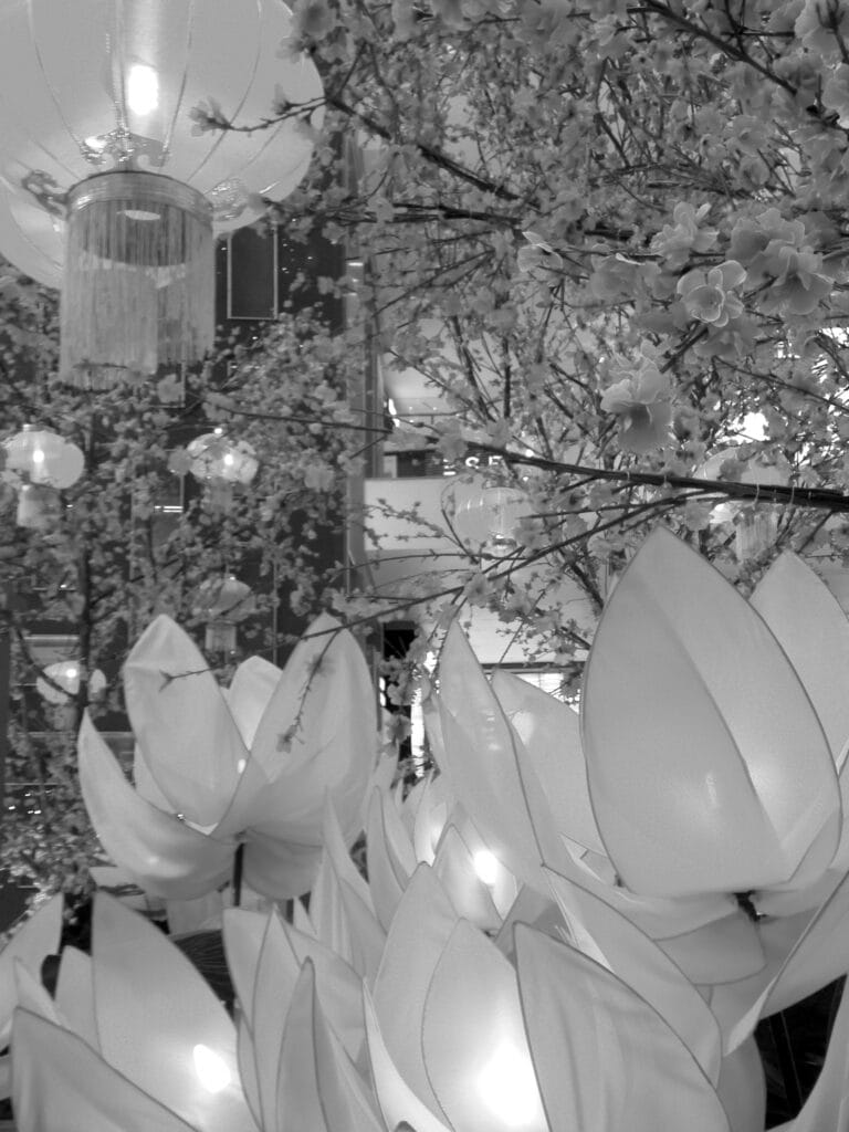 Decorations of blossoming tree branches and lanterns in a shopping centre.