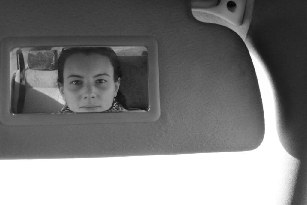 Self-portrait of the photographer in a vanity mirror, er chin too low to be reflected in the mirror.
