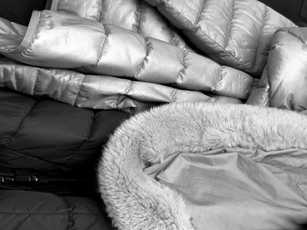 Down jackets hanging on a coat rack.