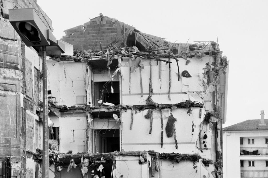 A three-storey building with its walls torn down, halfway from being demolished.