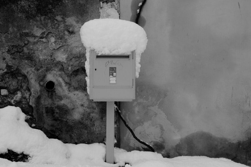 A letterbox covered in snow.