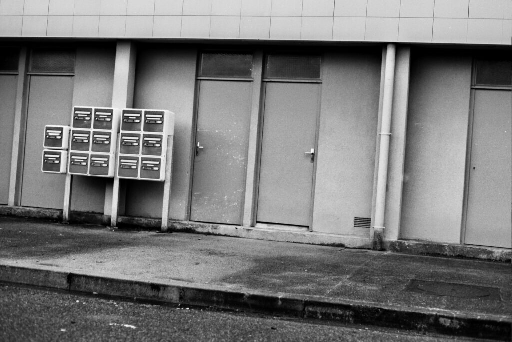 Part of a building façade featuring cellar doors and letterboxes.